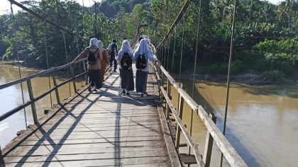 pelajar menyeberangi jembatan gantung Enrekang yang nyaris putus di Desa Lebang, Kecamatan Cendana