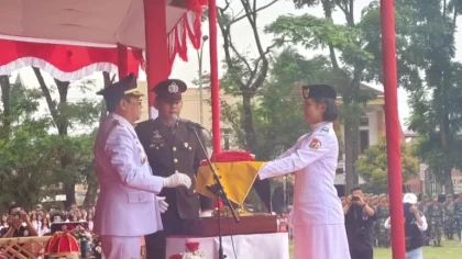 Dwijuni Asih Ahmad membawa baki bendera Merah Putih pada upacara HUT RI ke-80 di Toraja Utara