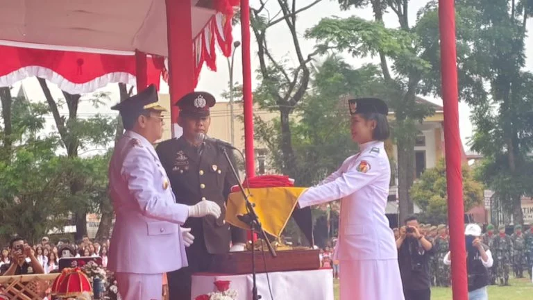 Dwijuni Asih Ahmad membawa baki bendera Merah Putih pada upacara HUT RI ke-80 di Toraja Utara