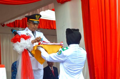 Camat Abd Rachman menyerahkan bendera Merah Putih kepada Paskibra dalam Upacara HUT RI Barombong