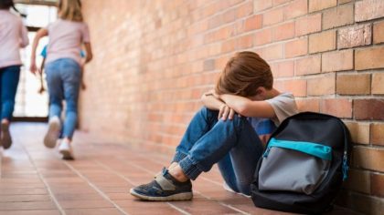 anak korban kasus bullying di sekolah duduk menyendiri di koridor sekolah